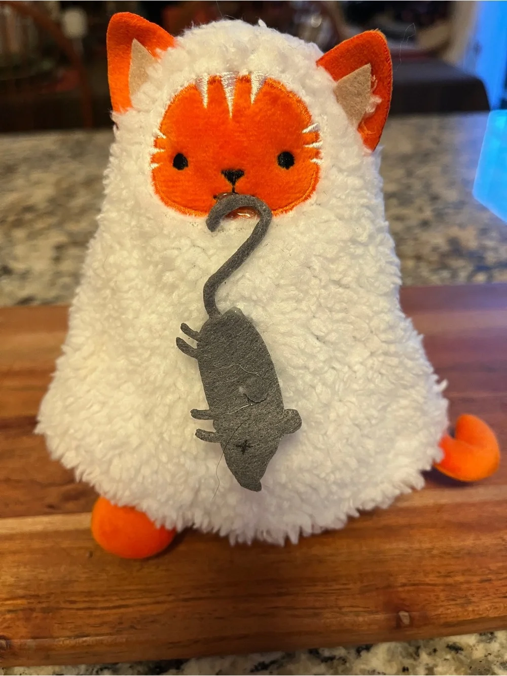 Plush soft small Cat disguised as a ghost costume showing off its mouse catch